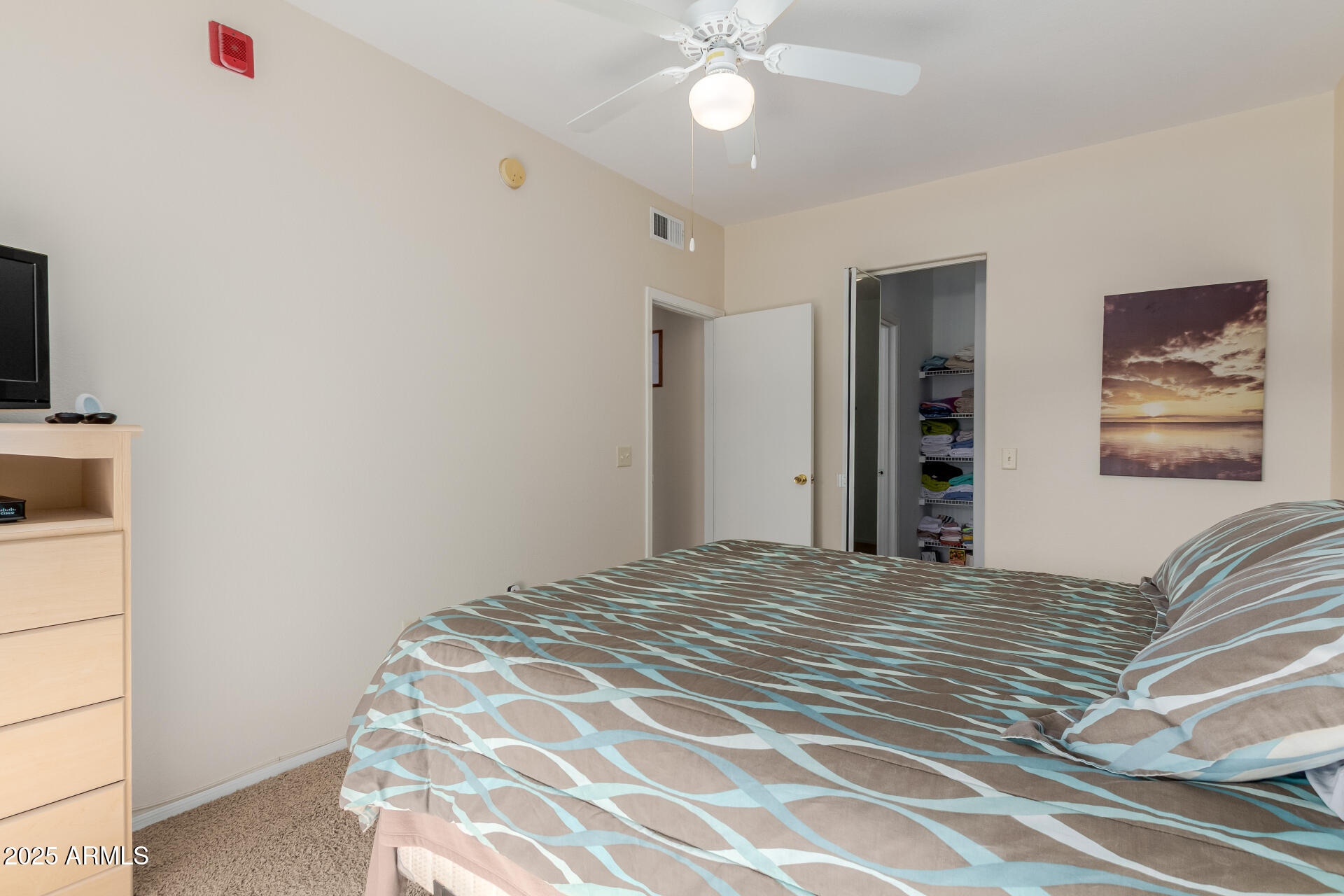 3434 East Baseline Road, Unit 246 Phoenix, AZ 85042 - Photo 17 of 43 a bedroom with a large bed and a chandelier