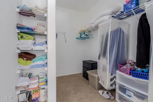 a view of walk in closet with clothes and shoes