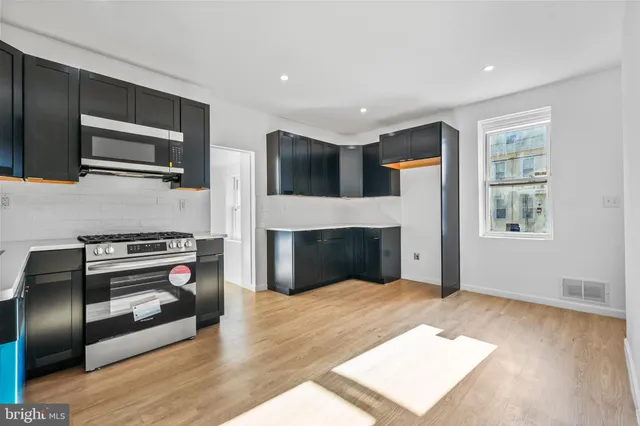 a kitchen with stainless steel appliances a stove microwave and sink