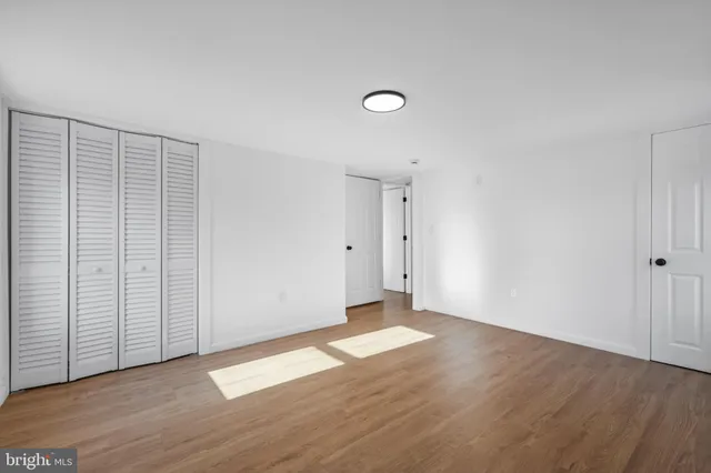 an empty room with wooden floor and white walls