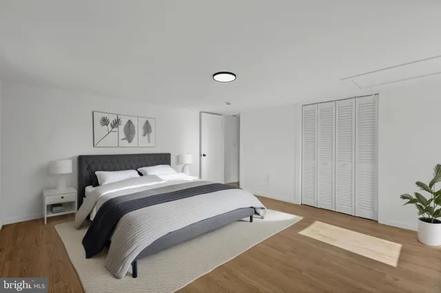 a bedroom with a bed and a potted plant on dresser