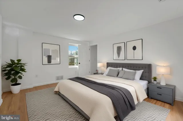 a bedroom with a bed and a potted plant