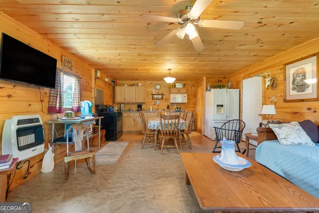 a living room with furniture a flat screen tv and kitchen view