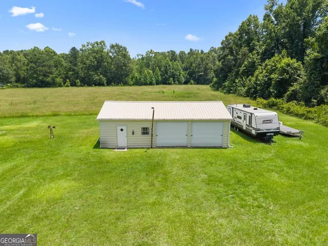 a view of a green field with trees in the background
