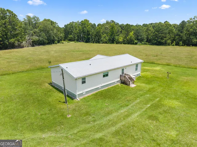 an aerial view of a houses with a yard and lake view