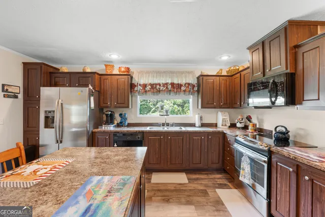 a kitchen with kitchen island a sink stove and refrigerator