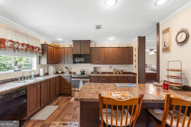 a large kitchen with stainless steel appliances kitchen island granite countertop a sink and cabinets