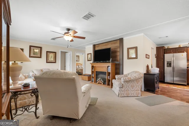 a living room with furniture and a flat screen tv with kitchen view