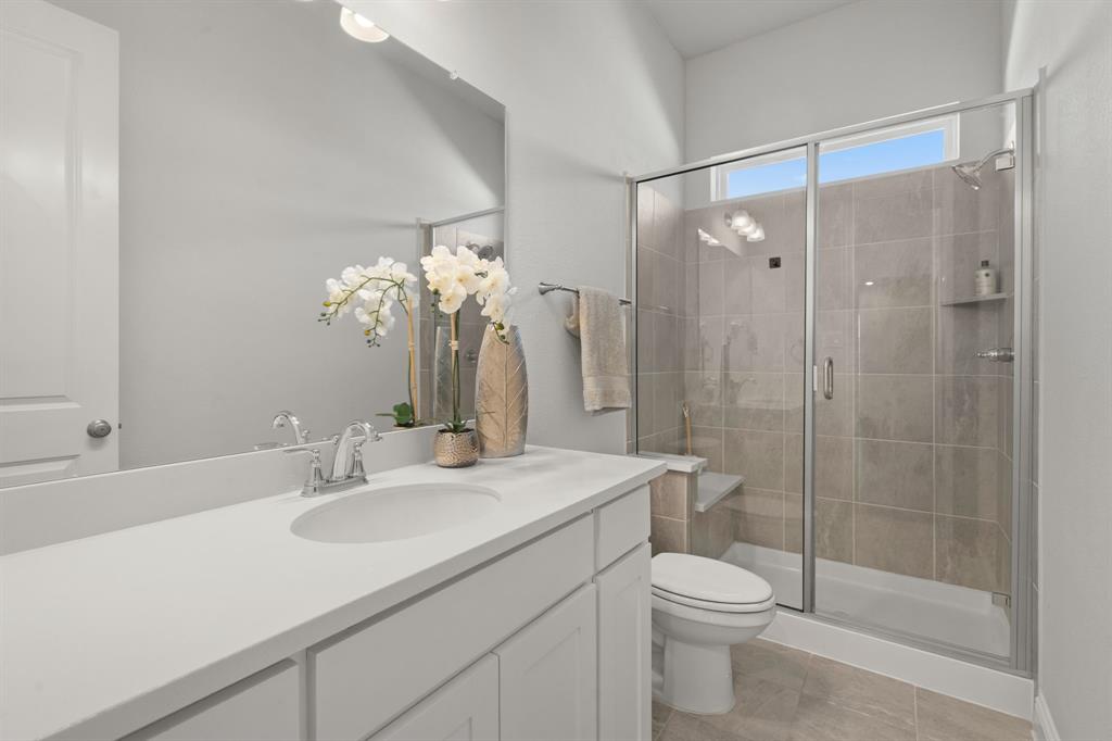 1320 Cartona Road Fate, TX 75087 - Photo 27 of 35 Walk-in shower with glass enclosure, built-in bench, and tiled walls