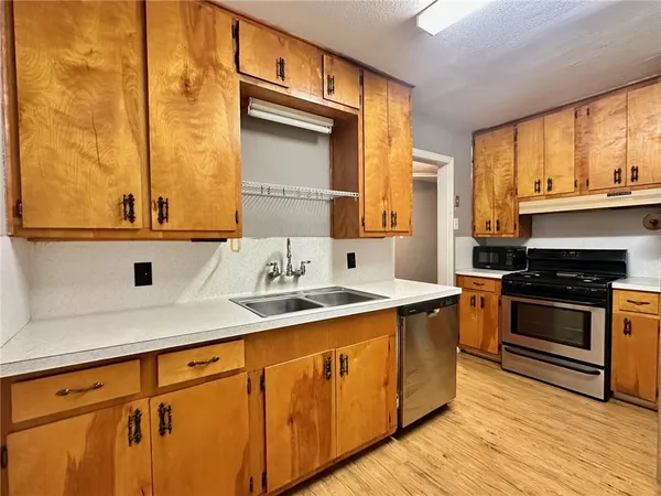 a kitchen with stainless steel appliances granite countertop a sink and a stove