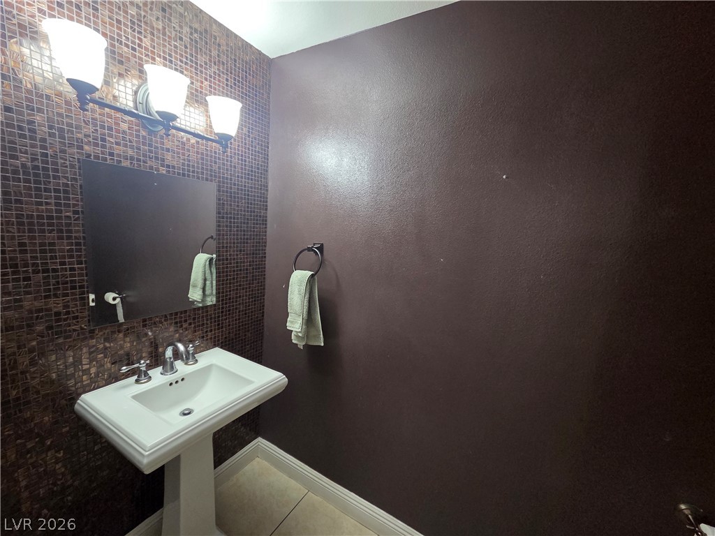 3381 Westwind Road Las Vegas, NV 89146 - Photo 20 of 52 A well-lit powder room offers contemporary style with a pedestal sink and mosaic tile.