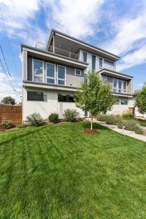 a front view of a house with a yard and potted plants