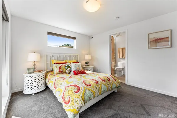 a bedroom with a bed and a painting on the wall