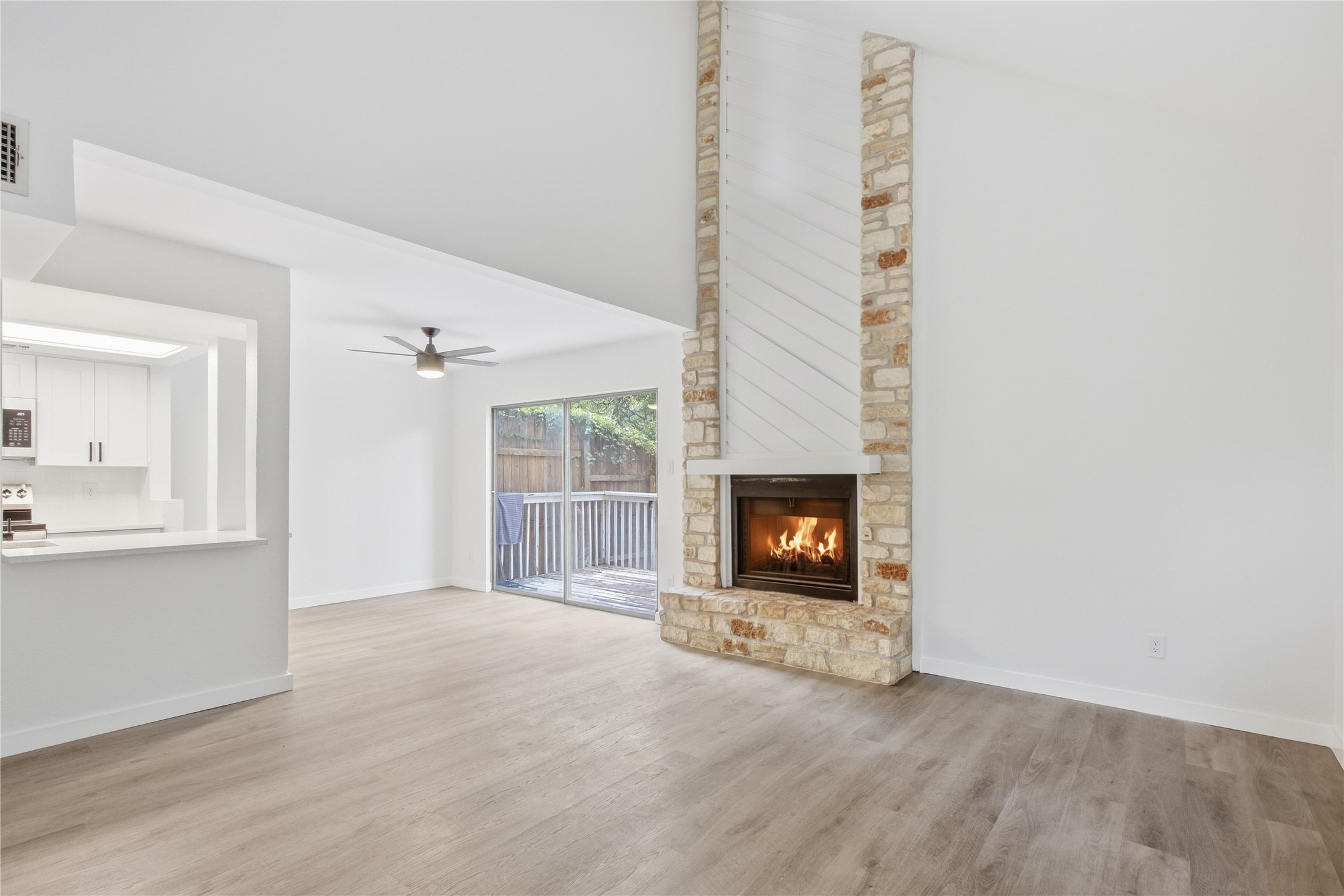 2500 Jones Road, Unit B Austin, TX 78745 - Photo 10 of 37 An impressive floor-to-ceiling stone fireplace anchors this airy living room with smooth wood-look flooring.