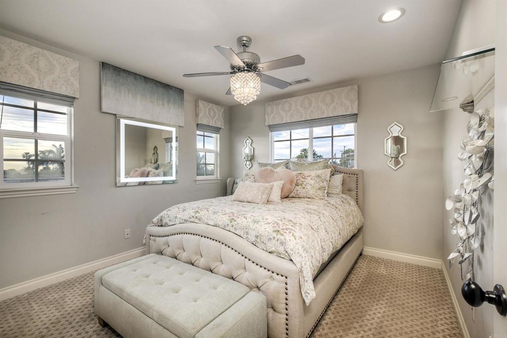 917 Santo Way Cardiff-by-the-Sea, CA 92007 - Photo 22 of 43 a bedroom with a large bed and a chandelier