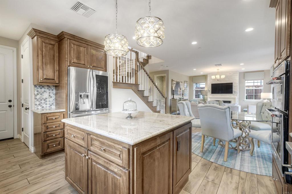 917 Santo Way Cardiff-by-the-Sea, CA 92007 - Photo 10 of 43 a view of living room kitchen island stainless steel appliances wooden floor and dining table