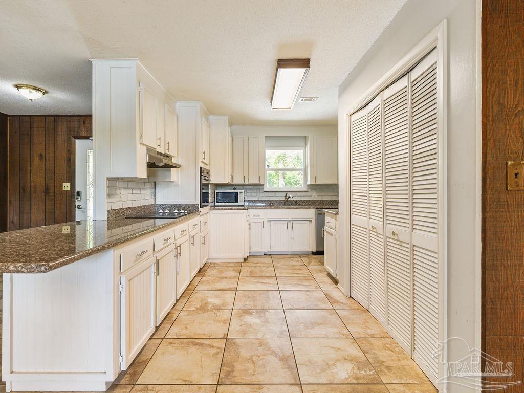 609 Dog Track Road Pensacola, FL 32506 - Photo 15 of 22 a large white kitchen with a sink and cabinets