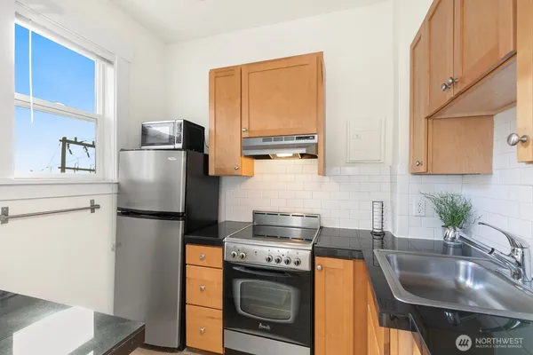 a kitchen with stainless steel appliances granite countertop a sink a stove and cabinets
