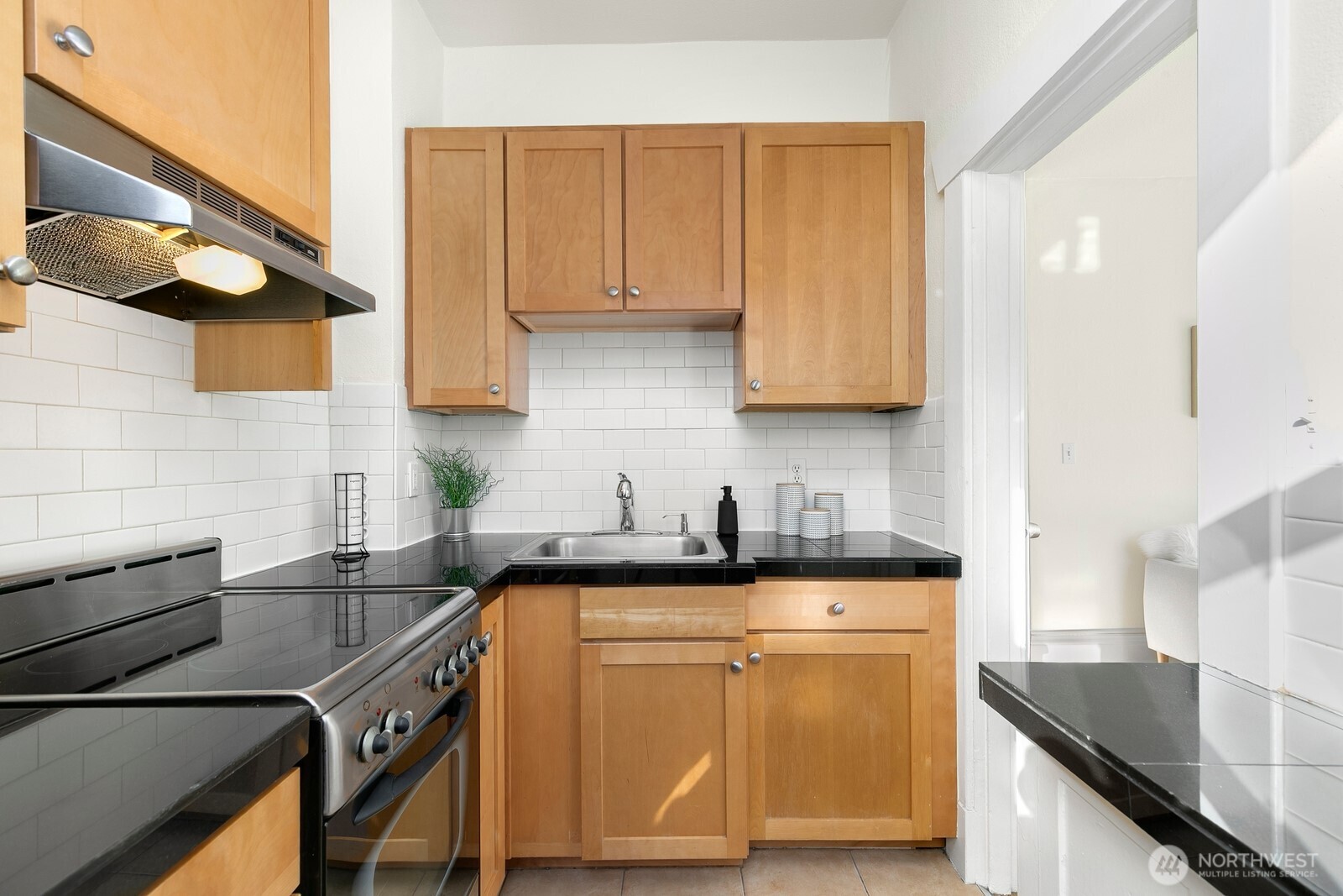 901 Northeast 43rd Street, Unit 306 Seattle, WA 98105 - Photo 14 of 23 a kitchen with granite countertop a sink a stove and cabinets