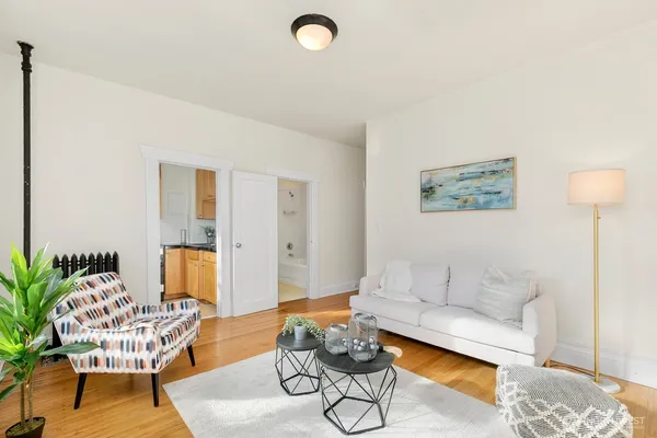 a living room with furniture and wooden floor