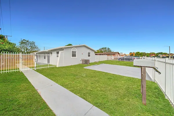 a view of a house with backyard and a tree