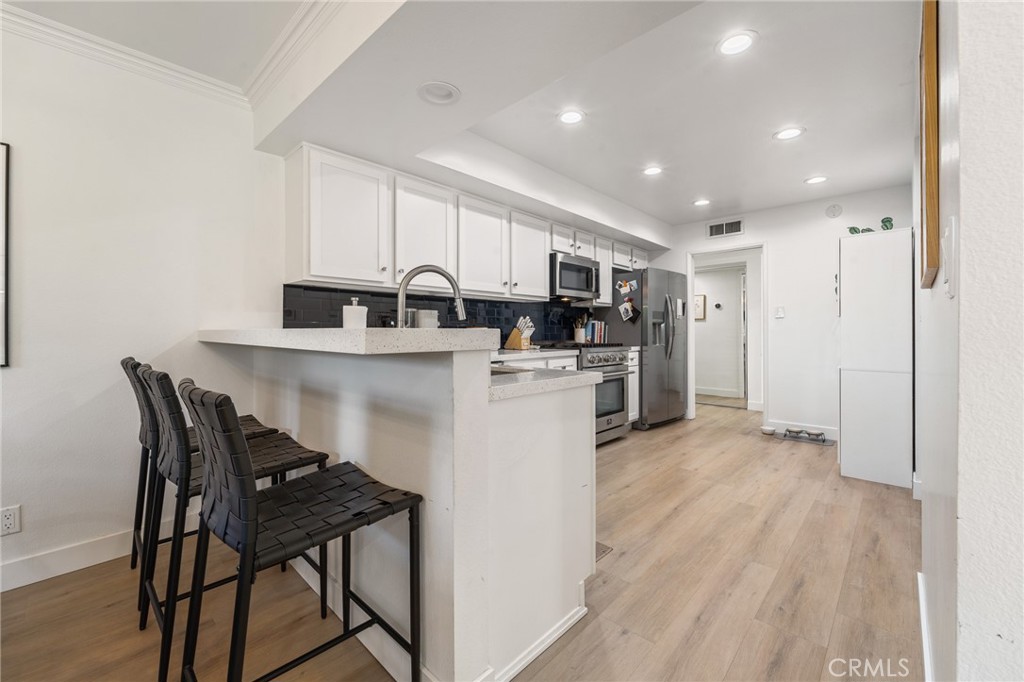 5440 Lindley Avenue, Unit 201 Encino, CA 91316 - Photo 13 of 38 a kitchen with appliances cabinets and wooden floor