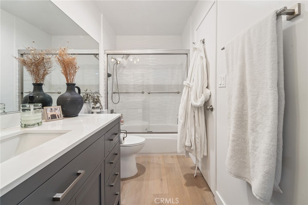 5440 Lindley Avenue, Unit 201 Encino, CA 91316 - Photo 18 of 38 a bathroom with a granite countertop sink toilet a shower and a mirror