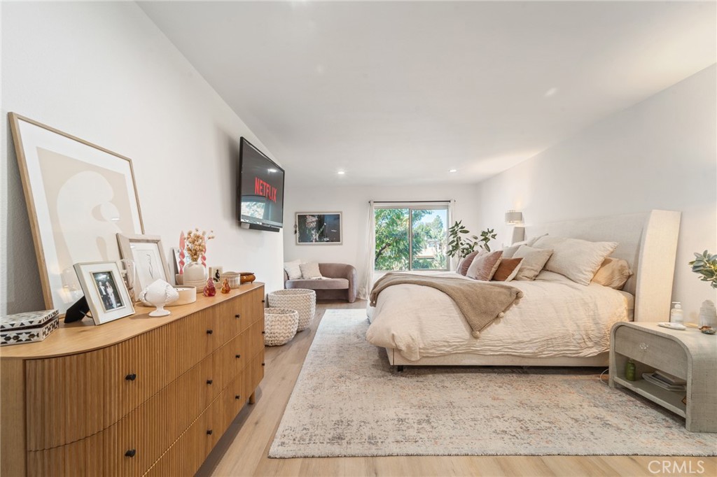 5440 Lindley Avenue, Unit 201 Encino, CA 91316 - Photo 23 of 38 a bedroom with a large bed and a flat tv screen on dresser