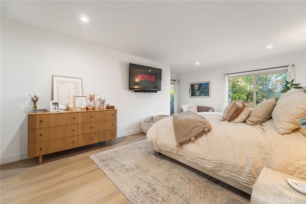 5440 Lindley Avenue, Unit 201 Encino, CA 91316 - Photo 24 of 38 a bedroom with a large bed and a flat tv screen on dresser