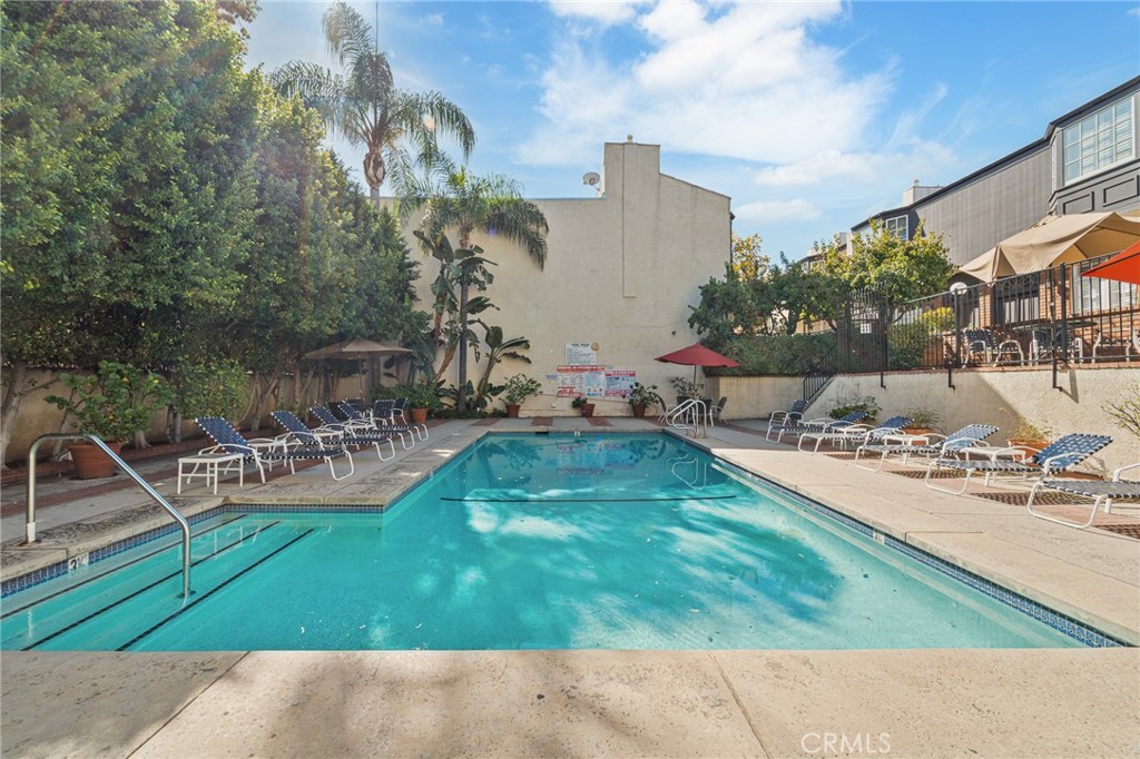 5440 Lindley Avenue, Unit 201 Encino, CA 91316 - Photo 31 of 38 a view of a swimming pool with lawn chairs and a fire pit