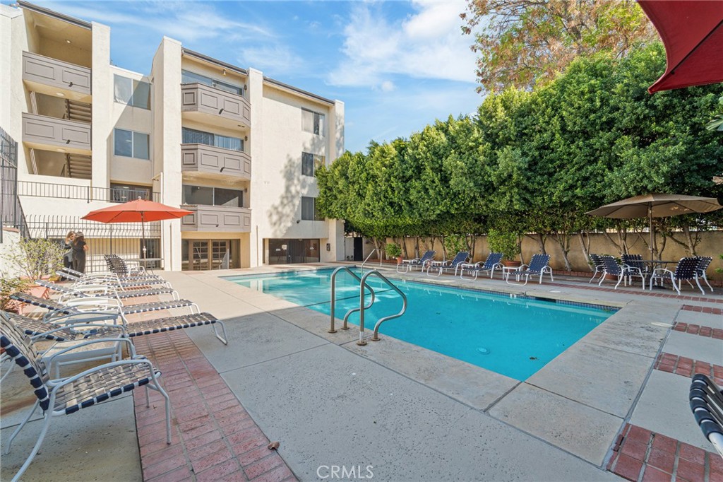 5440 Lindley Avenue, Unit 201 Encino, CA 91316 - Photo 33 of 38 a view of a patio with table and chairs under an umbrella