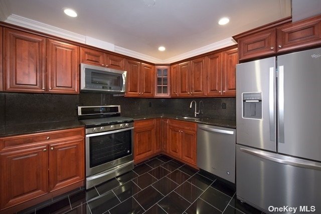 a kitchen with stainless steel appliances granite countertop a refrigerator stove top oven and sink