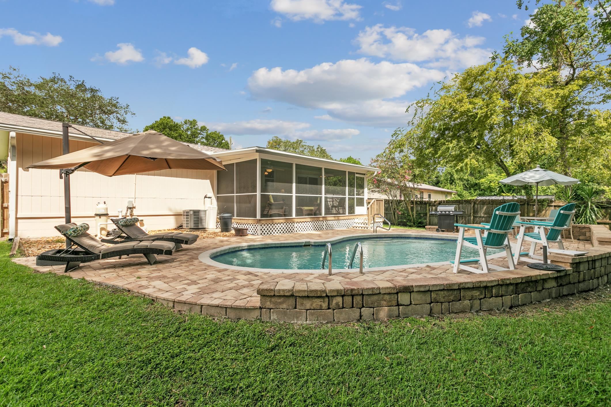 View of swimming pool featuring a fenced backyard, a patio, a sunroom, and a grill