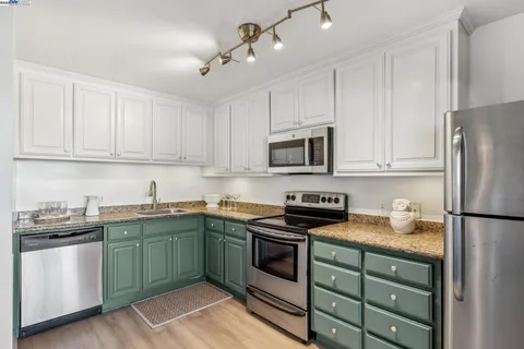 a kitchen with cabinets stainless steel appliances and a sink