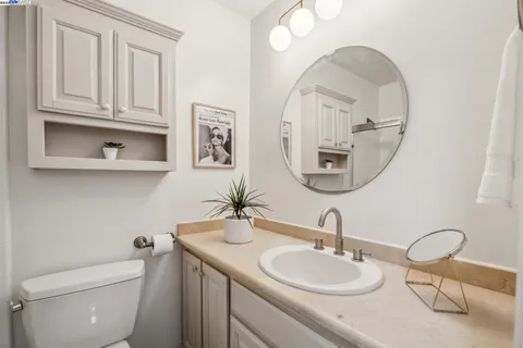 a bathroom with a toilet a sink and mirror