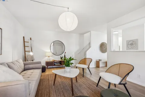 a living room with furniture kitchen view and a mirror