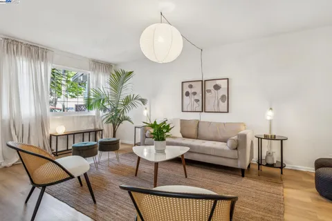 a living room with furniture a lamp and a large window