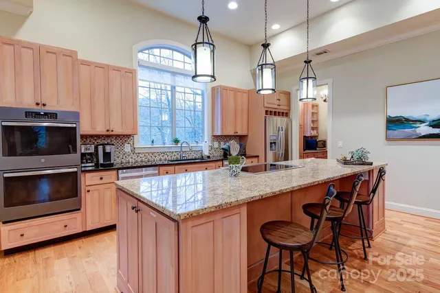 a kitchen with granite countertop a table chairs microwave and cabinets