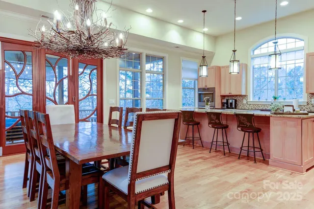 a dining room with furniture a chandelier and kitchen view