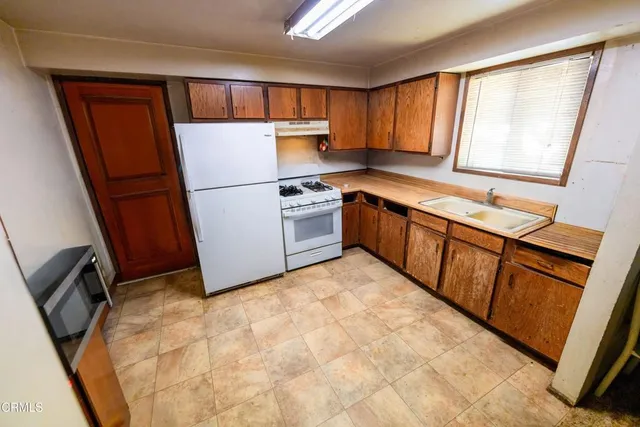 a kitchen with a refrigerator sink stove and cabinets