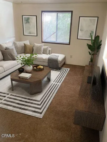 a living room with furniture and a potted plant