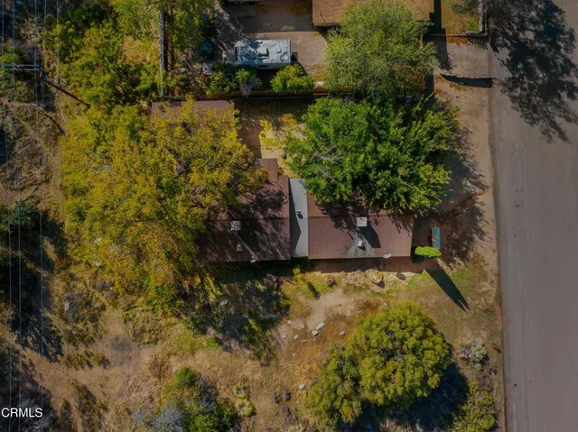an aerial view of a residential houses with yard