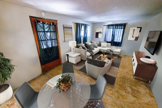 a living room with furniture fireplace and a large window