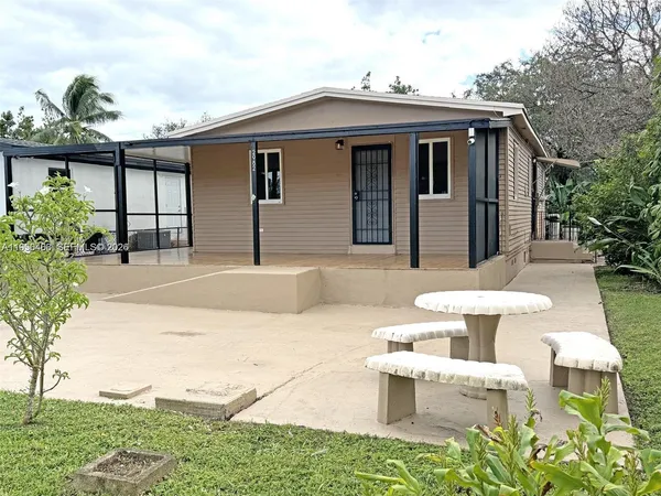 a view of a patio with couches table and chairs potted plants and a palm tree