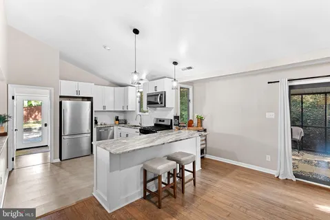 a kitchen with a refrigerator a sink and chairs