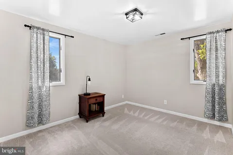 an empty room with windows and ceiling fan