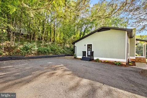 an aerial view of residential houses with outdoor space and trees all around