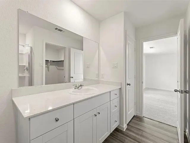 a spacious bathroom with a granite countertop sink and a mirror