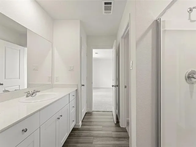 a spacious bathroom with a double vanity sink and mirror