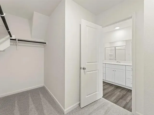 a view of walk in closet with white walls